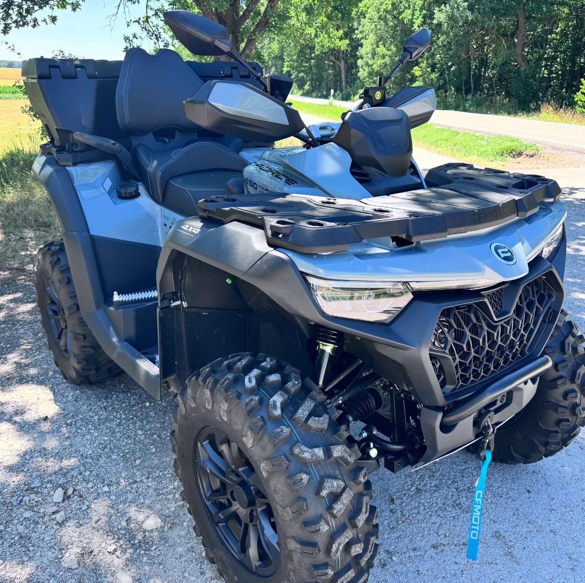 CFMOTO CFORCE 850 Touring ATV parked on a gravel road, trail-ready setup for off-road riding